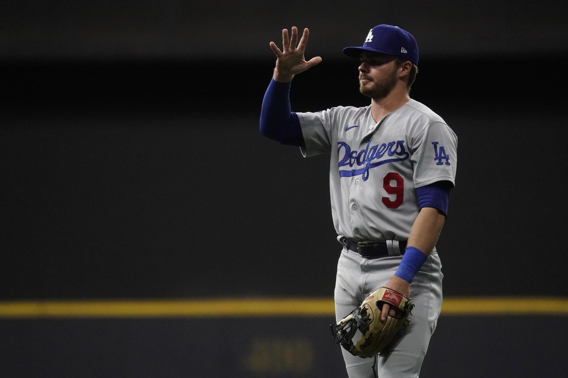 Dodgers player Gavin Lux holds up his hand while on the field