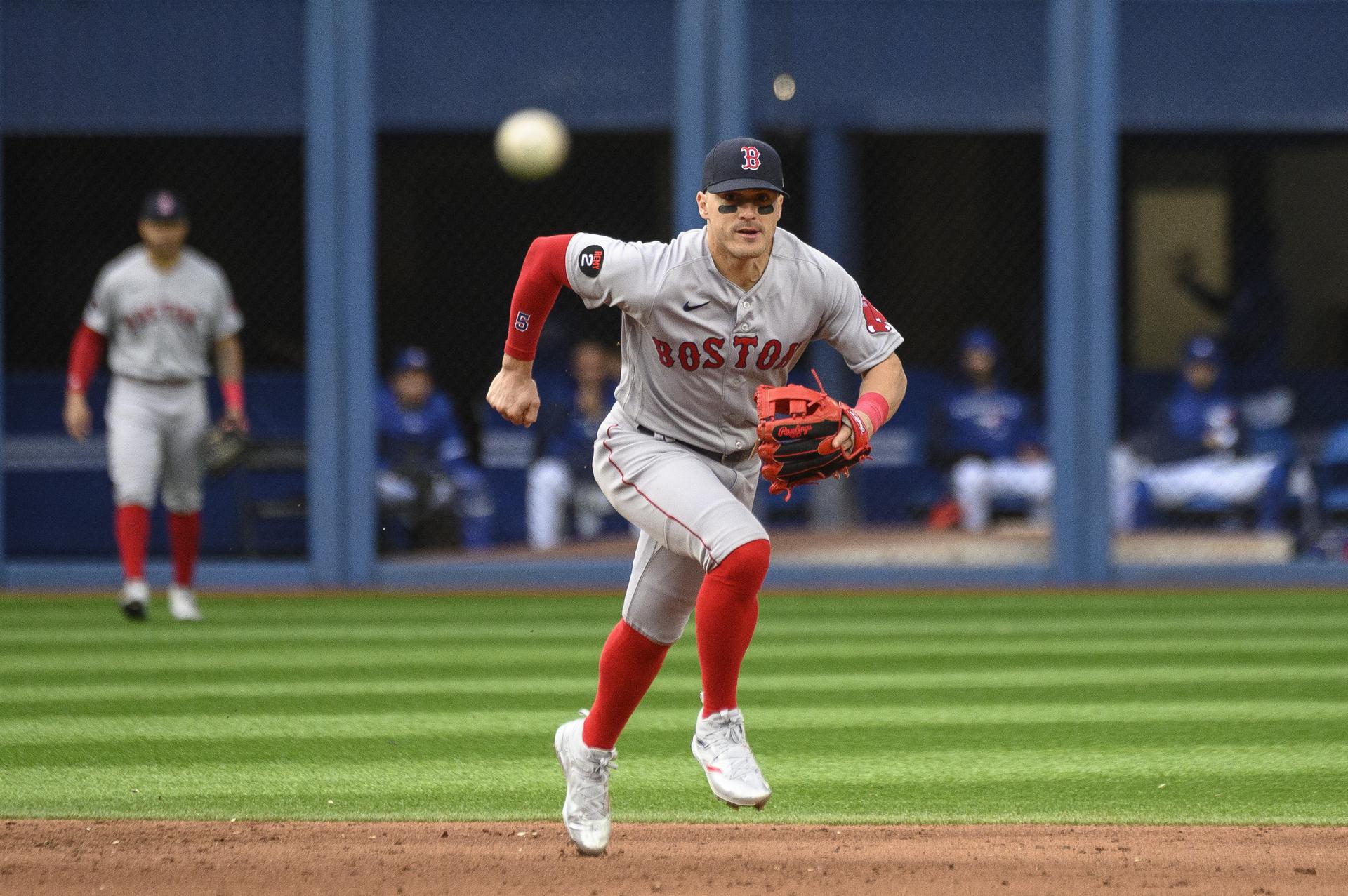Red Sox player Kiké Hernández lunges toward a ball coming at him at second base