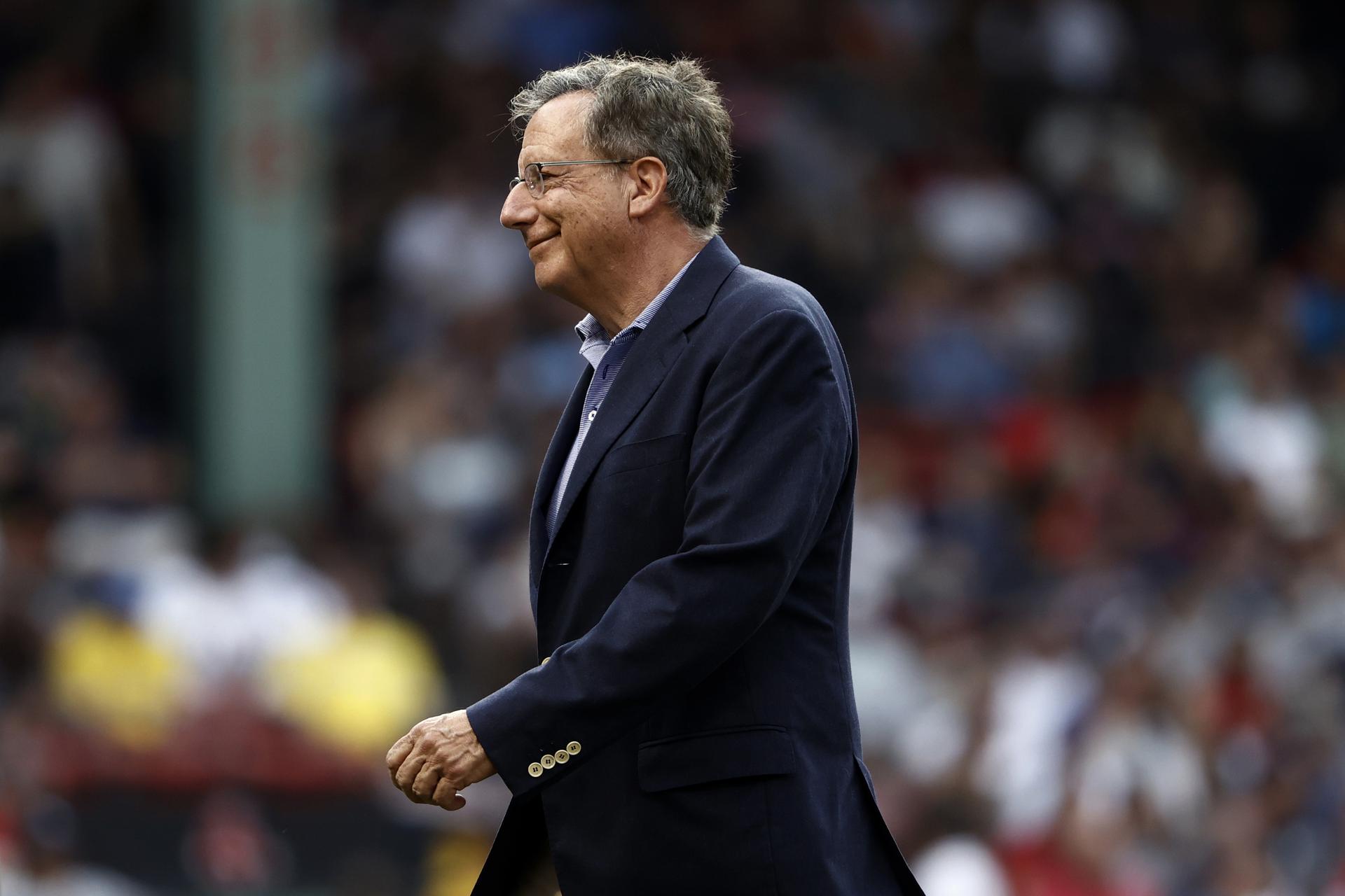 Red Sox chairman Tom Werner smiles as he walks across the field at Fenway Park