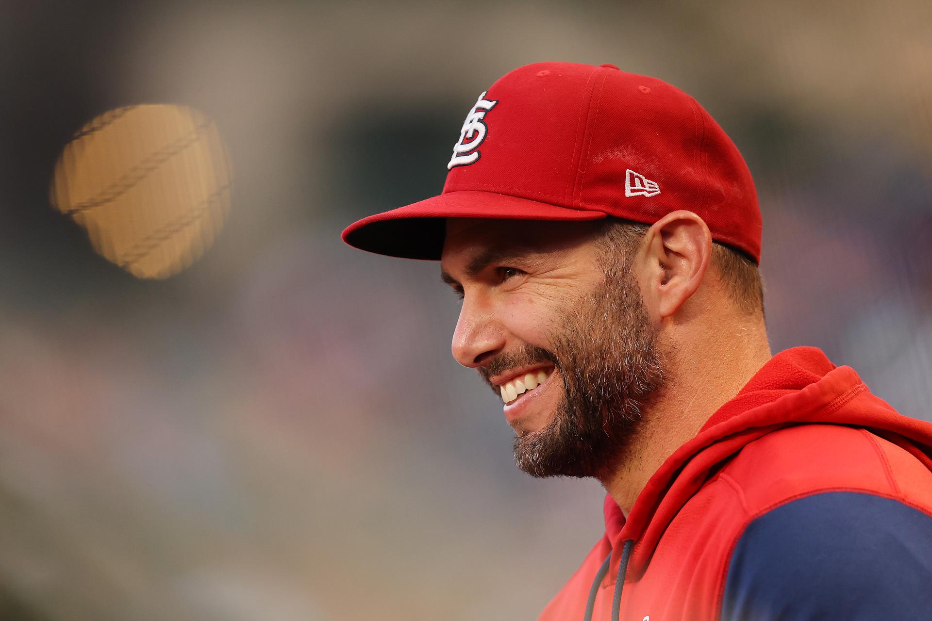 Cardinals player Paul Goldschmidt smiles while wearing a red hat and red hoodie