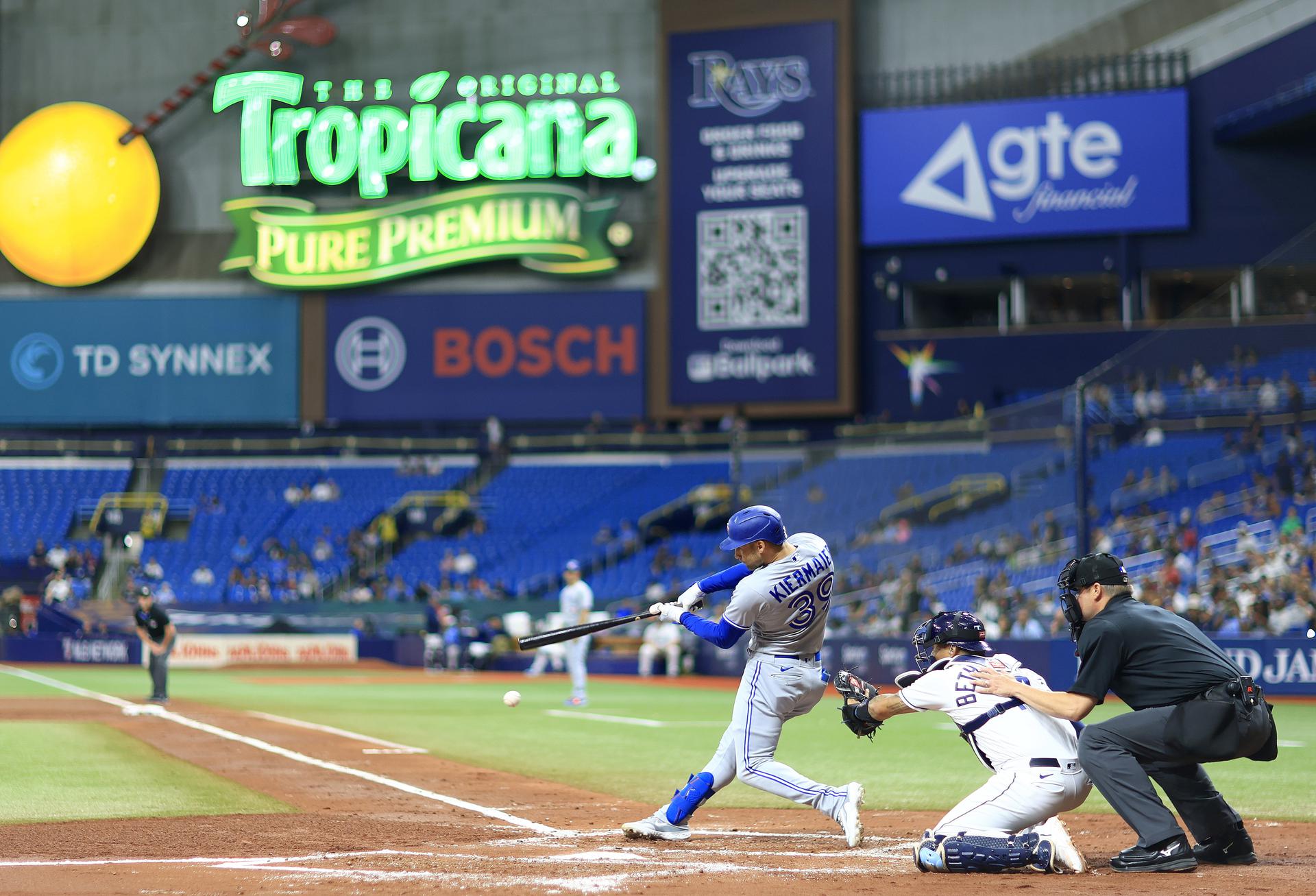 Kevin Kiermaier swings the bat at Tropicana Field, with the Tropicana Field logo in the distance