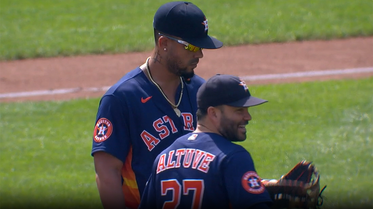 José Abreu looks at his glove while Jose Altuve laughs