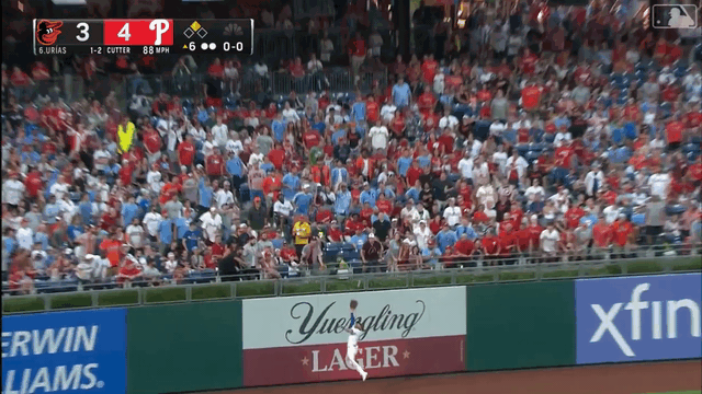 An animated gif of Phillies outfielder Jake Cave running into the wall and falling down