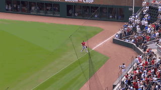 An animated gif of Nick Castellanos making a catch, spinning and throwing to the plate