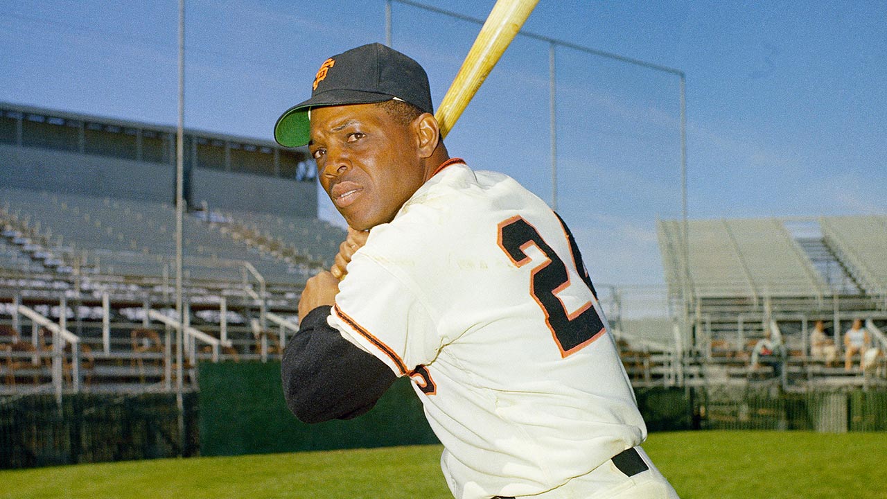 Willie Mays holds a bat in a posed picture