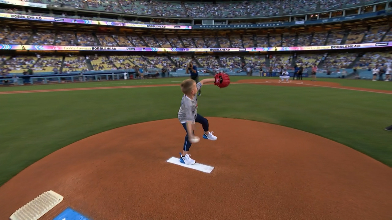 A young boy winds up from the pitcher's mound to deliver the game's first pitch