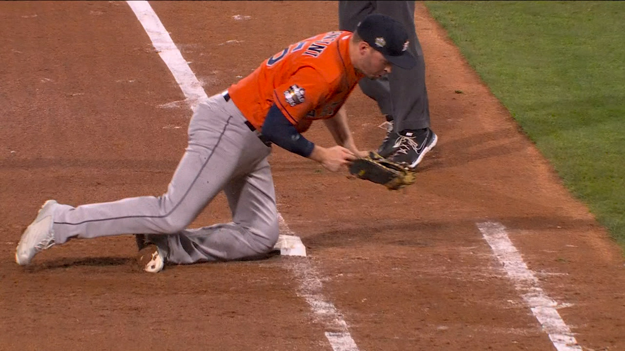 Trey Mancini falls to one knee after fielding a grounder at first base