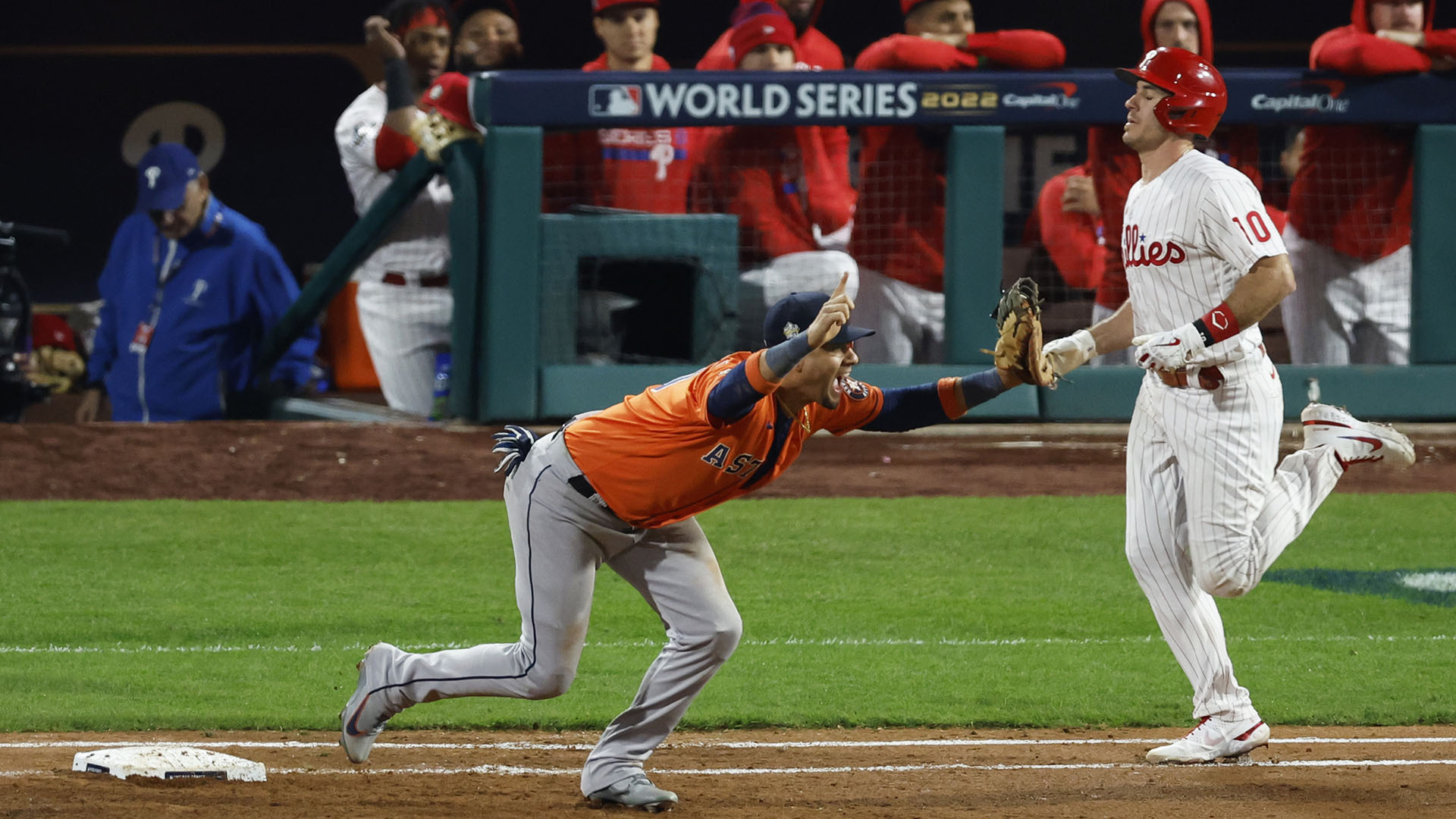 Astros first baseman Yuli Gurriel raises his arms to celebrate after catching the last out as Phillies batter J.T. Realmuto arrives late at first base