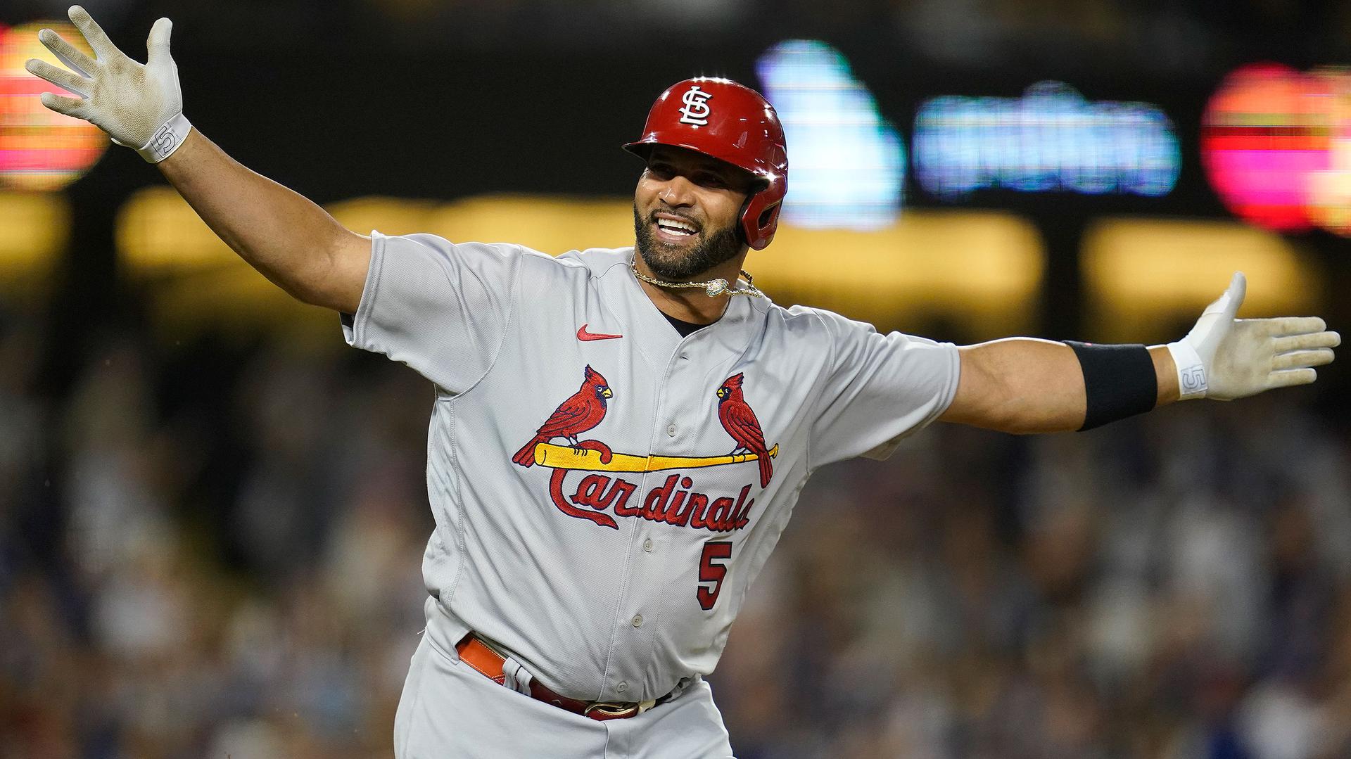 Albert Pujols, with arms outstretched, celebrates his 700th career home run